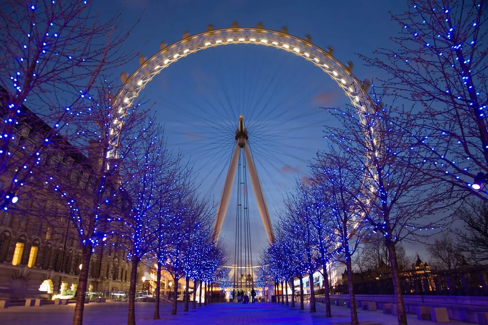 La ruota panoramica del London Eye che si erge sopra il lungofiume pianeggiante di South Bank