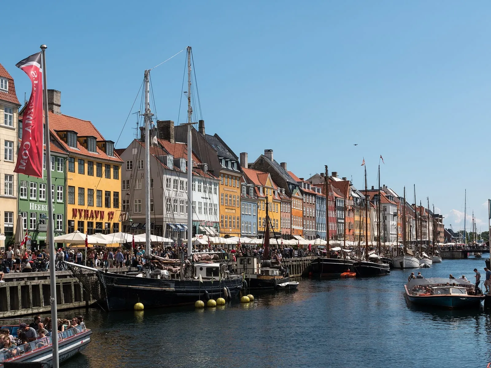 Des maisons colorées le long du quai de Nyhavn au-dessus d'un chemin de plain-pied en bord d'eau