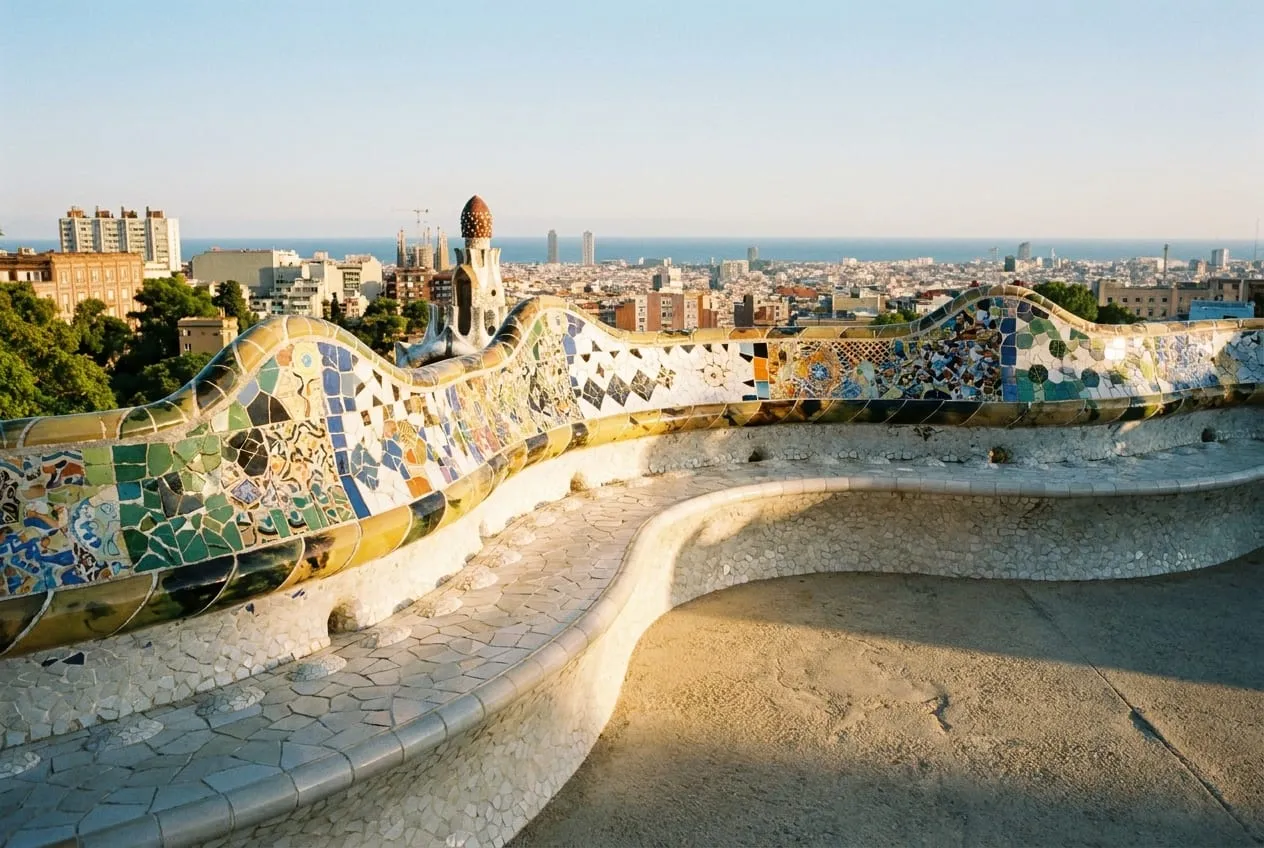 The mosaic serpentine bench curving around the main terrace of Park Güell with the city beyond